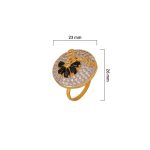 Large circular brass statement ring featuring gold and white dual-tone finish with a black floral stone design in the center