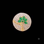 Large circular brass statement ring featuring gold and white dual-tone finish with a green floral stone design in the center
