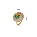 Large circular brass statement ring featuring gold and white dual-tone finish with a green floral stone design in the center
