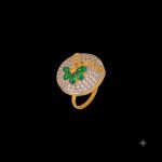 Large circular brass statement ring featuring gold and white dual-tone finish with a green floral stone design in the center