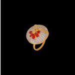Large circular brass statement ring featuring gold and white dual-tone finish with a red floral stone design in the center