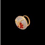 Large circular brass statement ring featuring gold and white dual-tone finish with a red floral stone design in the center