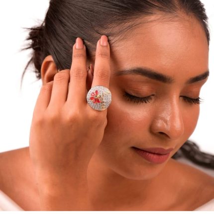 Large circular brass statement ring featuring gold and white dual-tone finish with a red floral stone design in the center