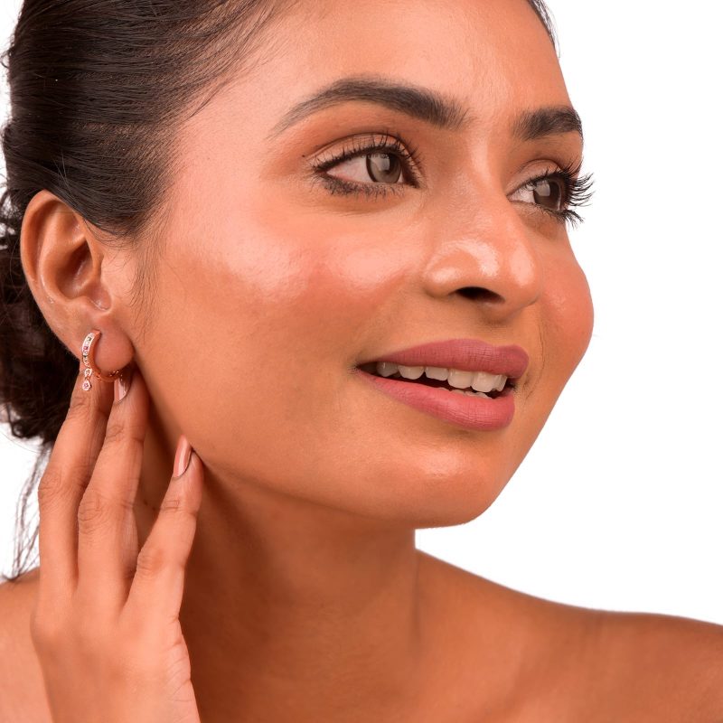 Curved Multi-Row CZ Huggie Hoop Earrings with Teardrop Accent worn by a model